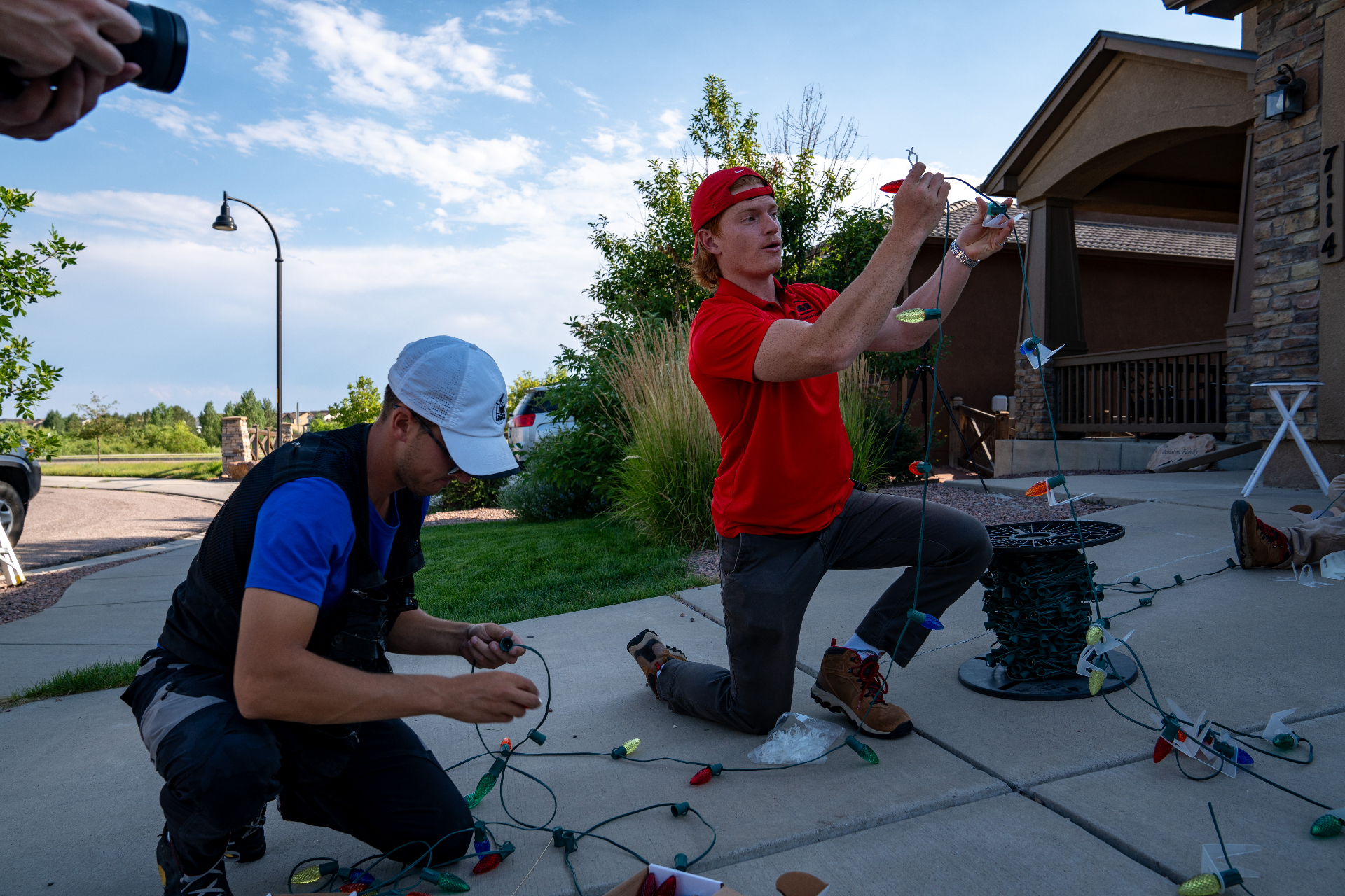 C&B installer hanging Christmas lights on a roofline